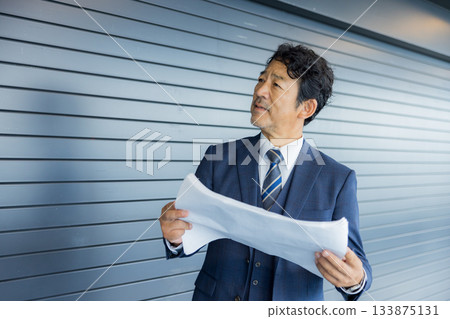 A businessman thinking in front of a store property 133875131