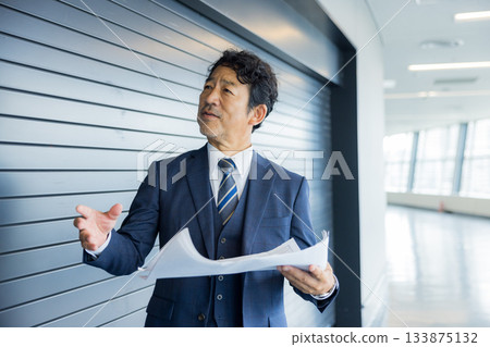 A businessman thinking in front of a store property 133875132