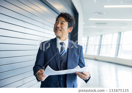 A businessman thinking in front of a store property 133875135