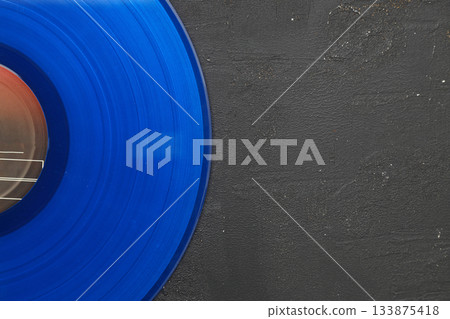 Blue Vinyl record on a black stone background. Retro style. Top view. Blue Vinyl record on a black stone background. Retro style. Top view. 133875418