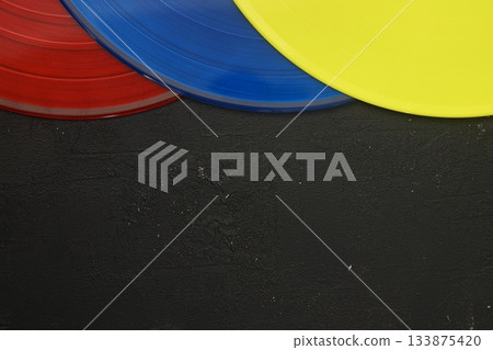 colorful Vinyl record on a black background. Retro style. Top view. Flat lay, copy space. colorful Vinyl record on a black background. Retro style. Top view. Flat lay, copy space. 133875420
