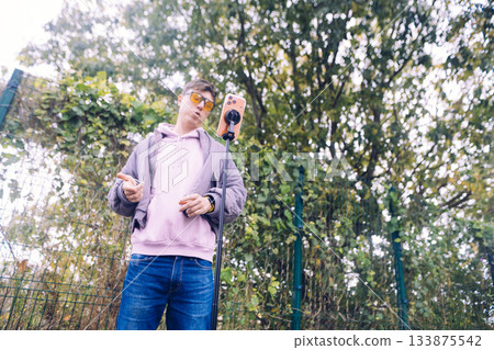 Singer recording melody in natural setting with equipment visible Singer recording melody in natural setting with equipment visible 133875542