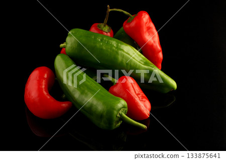 red and green chili peppers on black background. 133875641