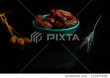 Dried dates on a wooden table in silver dishes close-up. Composition of dried dates in ramadan dish 133875646