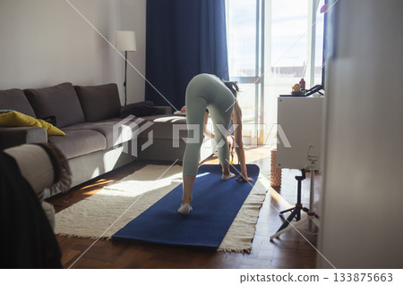 caucasian woman practicing forward fold for hamstring flexibility 133875663