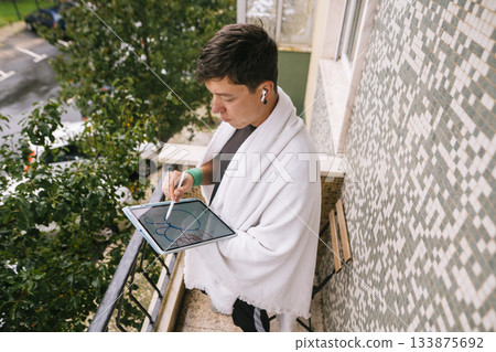 Young man with leafy cityscape background drawing confidently Young man with leafy cityscape background drawing confidently 133875692