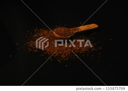 Coffee beans in a wooden scoop isolated on a black background. Roasted coffee beans isolated. 133875709