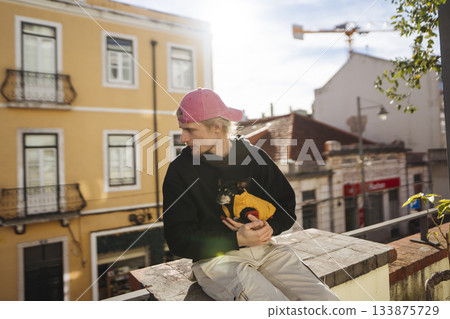 Urban scene featuring singersongwriter with guitar and small dog Urban scene featuring singersongwriter with guitar and small dog 133875729
