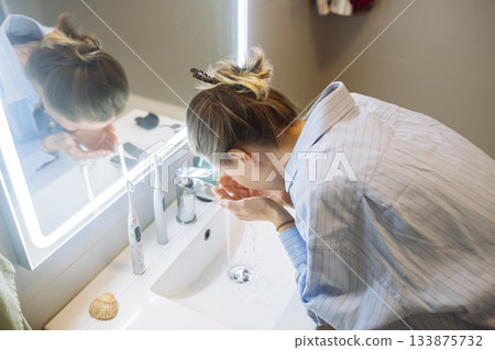 She methodically scrub her face to ensure cleanliness and freshness She methodically scrub her face to ensure cleanliness and freshness 133875732