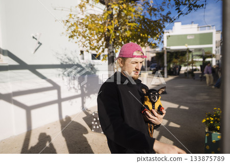 man reacting with animated expression beside chihuahua 133875789
