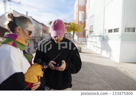 Two individuals collaborating on creative project beneath sunny sky 133875800