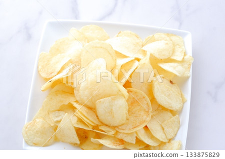 Potato chips - A plate full of potato chips Potato chips - A plate full of potato chips 133875829