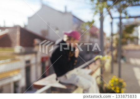 blurred creator on balcony with phone, influencer shot blurred creator on balcony with phone, influencer shot 133875833
