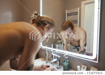 Person calmly examines how they present themselves visually 133875923