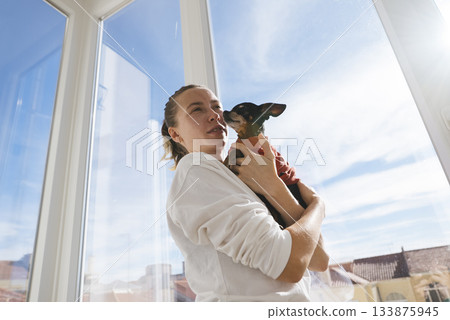 Affectionate woman displaying trust with vibrant feathered companion Affectionate woman displaying trust with vibrant feathered companion 133875945