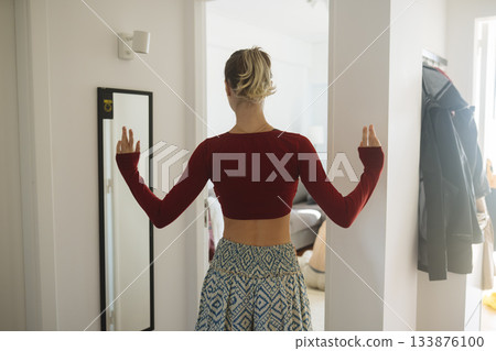 Caucasian woman practicing morning ritual in narrow corridor Caucasian woman practicing morning ritual in narrow corridor 133876100