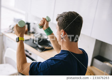 White man busy professional squeezing dumbbell workout during breakfast 133876263