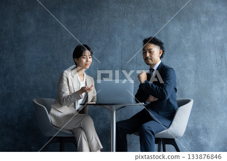 一位商務人士坐在椅子上工作 一位商務人士坐在椅子上工作 133876846