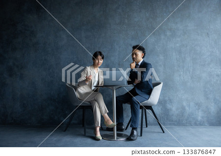A business person sitting in a chair and working 133876847