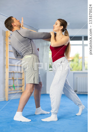 Woman and man practicing self defense techniques Woman and man practicing self defense techniques 133878024