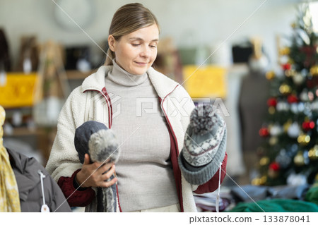 Young woman choosing hat in clothing store 133878041