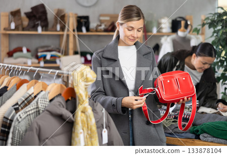 Adult woman choosing handbag in clothing store Adult woman choosing handbag in clothing store 133878104
