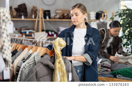 Woman browsing goods items and choose elect something autumn outwear Woman browsing goods items and choose elect something autumn outwear 133878163