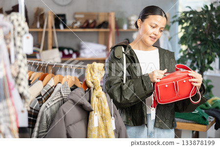 Asian woman browsing goods items and choose elect ladys bag Asian woman browsing goods items and choose elect ladys bag 133878199