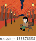 A carpet of fallen maple leaves on a tree-lined street with benches and streetlights 133878358