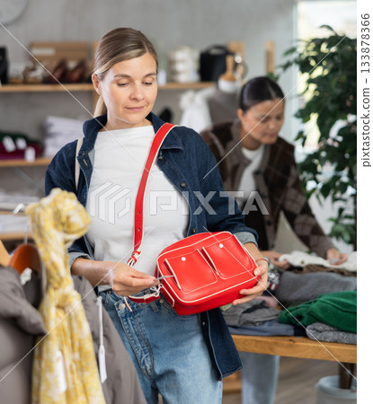 Woman browsing goods items and choose elect ladys bag Woman browsing goods items and choose elect ladys bag 133878366