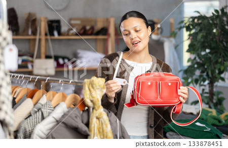 Asian woman browsing goods items and choose elect ladys bag Asian woman browsing goods items and choose elect ladys bag 133878451