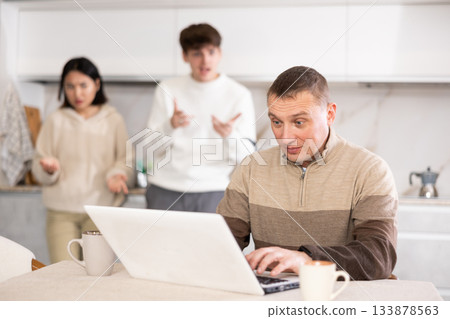 Couple quarreling with adult man with laptop Couple quarreling with adult man with laptop 133878563
