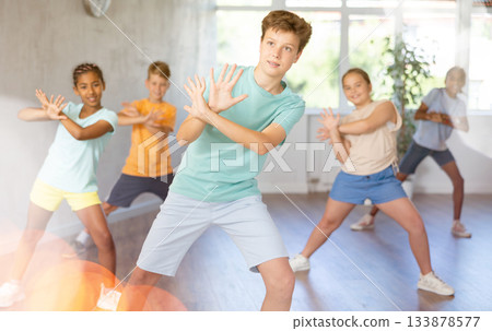 Cheerful tween boy practicing energetic dance in choreography class Cheerful tween boy practicing energetic dance in choreography class 133878577