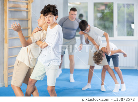 Teenagers trying to break free of back grab in sparring at self-defense training 133878578