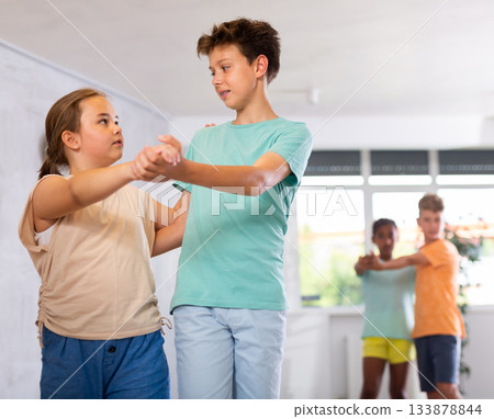 Active preteen children practicing Ballroom dances in pairs in training hall 133878844
