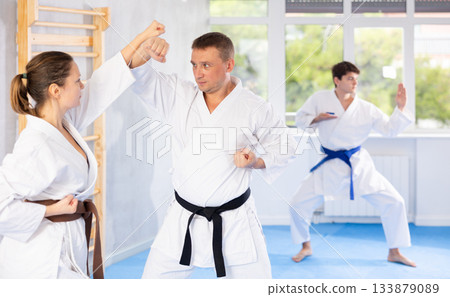 Man and woman train to perform basic defensive attacking actions during mortal techniques classes Man and woman train to perform basic defensive attacking actions during mortal techniques classes 133879089