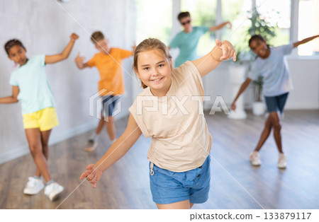 Girl perform choreographic exercises and teach energetic social dance waacking with friends 133879117