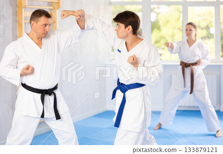 Two men are trained to perform basic defensive karate installations and attacking combat techniques 133879121