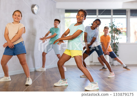 African girl perform choreographic exercises and teach energetic social dance waacking with friends 133879175