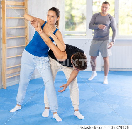 Woman makes a choke hold in self defense trainin Woman makes a choke hold in self defense trainin 133879176