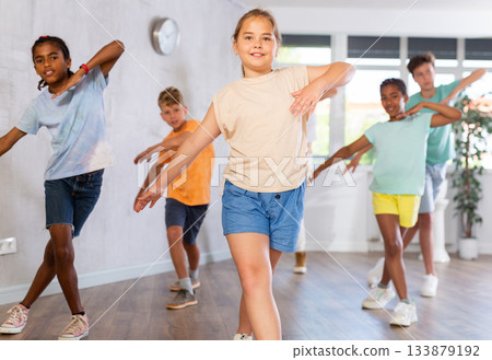 Portrait of girls and boys doing hip hop movements during group class in dance studio Portrait of girls and boys doing hip hop movements during group class in dance studio 133879192