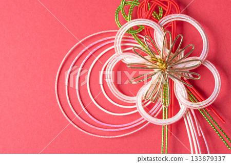 Gorgeous mizuhiki decorations placed on a red background 133879337