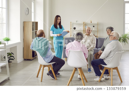Group of happy senior people at retirement home having discussion with young nurse 133879359