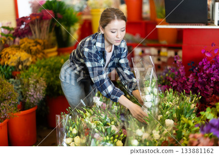 Female customer chooses a bouquet of roses in flower shop Female customer chooses a bouquet of roses in flower shop 133881162