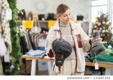 Selective young woman choosing hat in clothing store Selective young woman choosing hat in clothing store 133881182