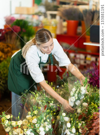 Florist creates bouquet of roses in flower shop Florist creates bouquet of roses in flower shop 133881191
