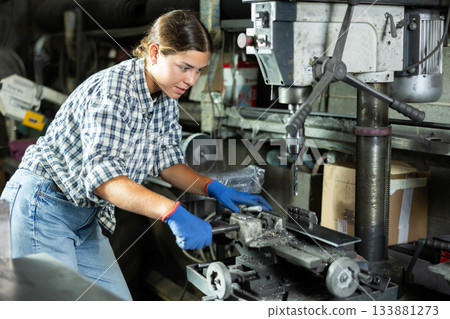 Young woman working with drill machine 133881273