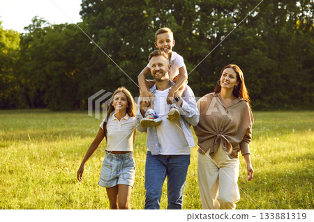 Happy family of four with kids walking in summer park enjoying beautiful nature. Happy family of four with kids walking in summer park enjoying beautiful nature. 133881319