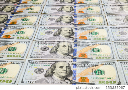 A clear composition of US $100 bills arranged at an angle 133882067