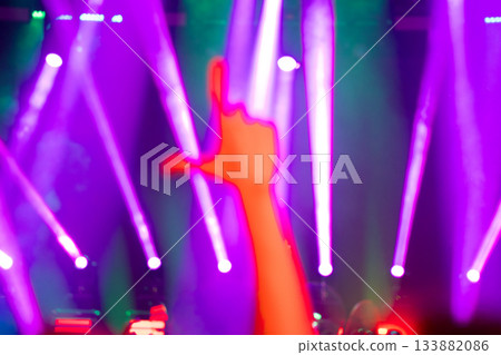 Concert lights with raised arm silhouette and pink glow Concert lights with raised arm silhouette and pink glow 133882086
